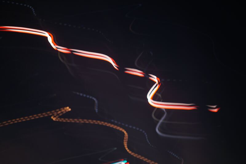 Red, white and orange streaks of light curving across a black background.